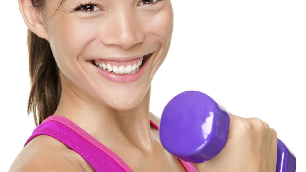 Fitness sport girl smiling happy. Fitness woman lifting dumbbells strength training biceps doing curls. Mixed Caucasian and Asian fitness model portrait isolated on white background.